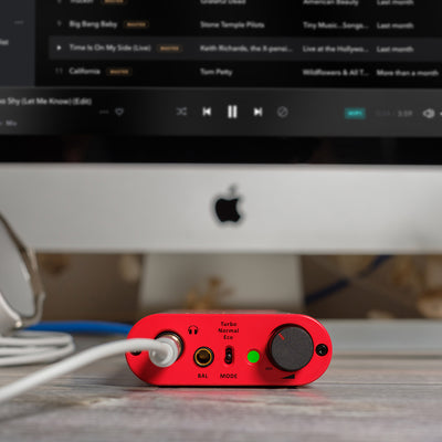 Red USB digital to analog audio device plugged into a desktop computer